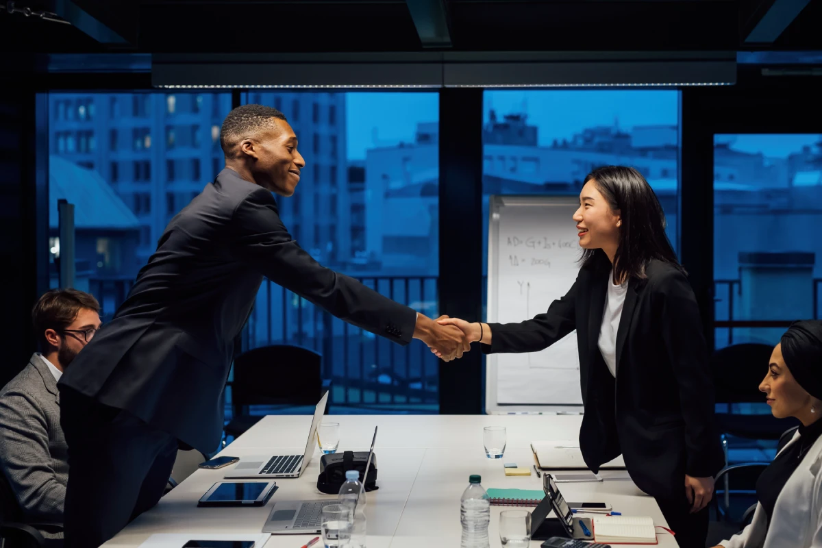 Professionnels en affaires concluant un partenariat B2B dans un bureau moderne